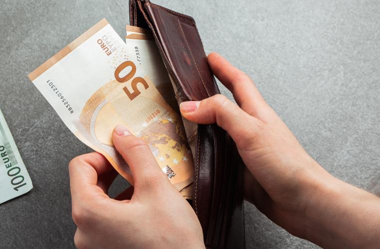 Main qui sort des billets de banque d'un portefeuille