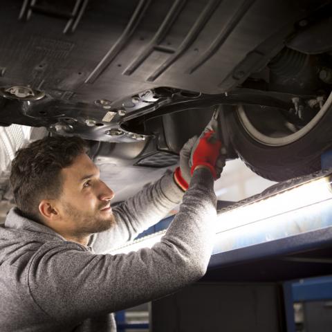 Man checkt banden van wagen op een brug